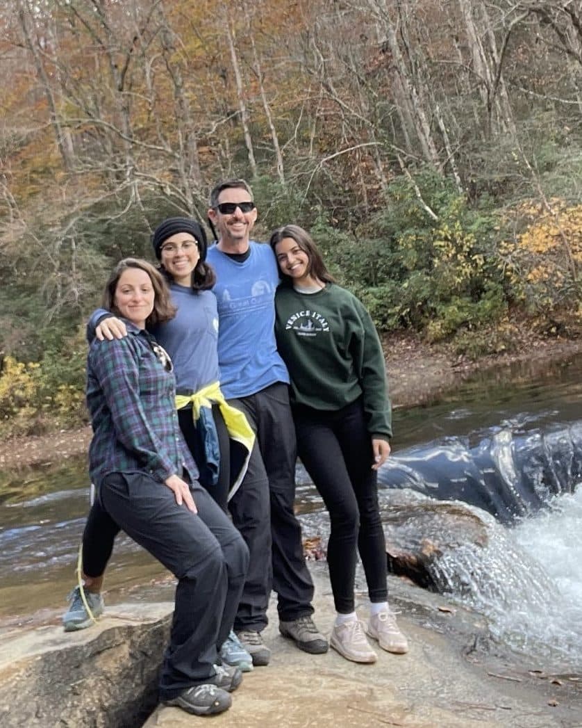 Sean Farro with his wife and their two daughters beside a waterfall.